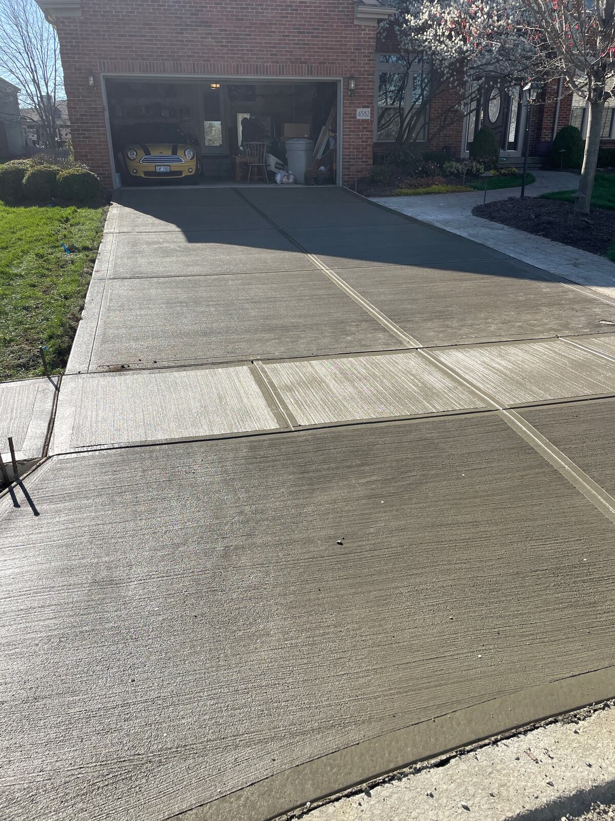 New concrete driveway and apron at a brick garage
