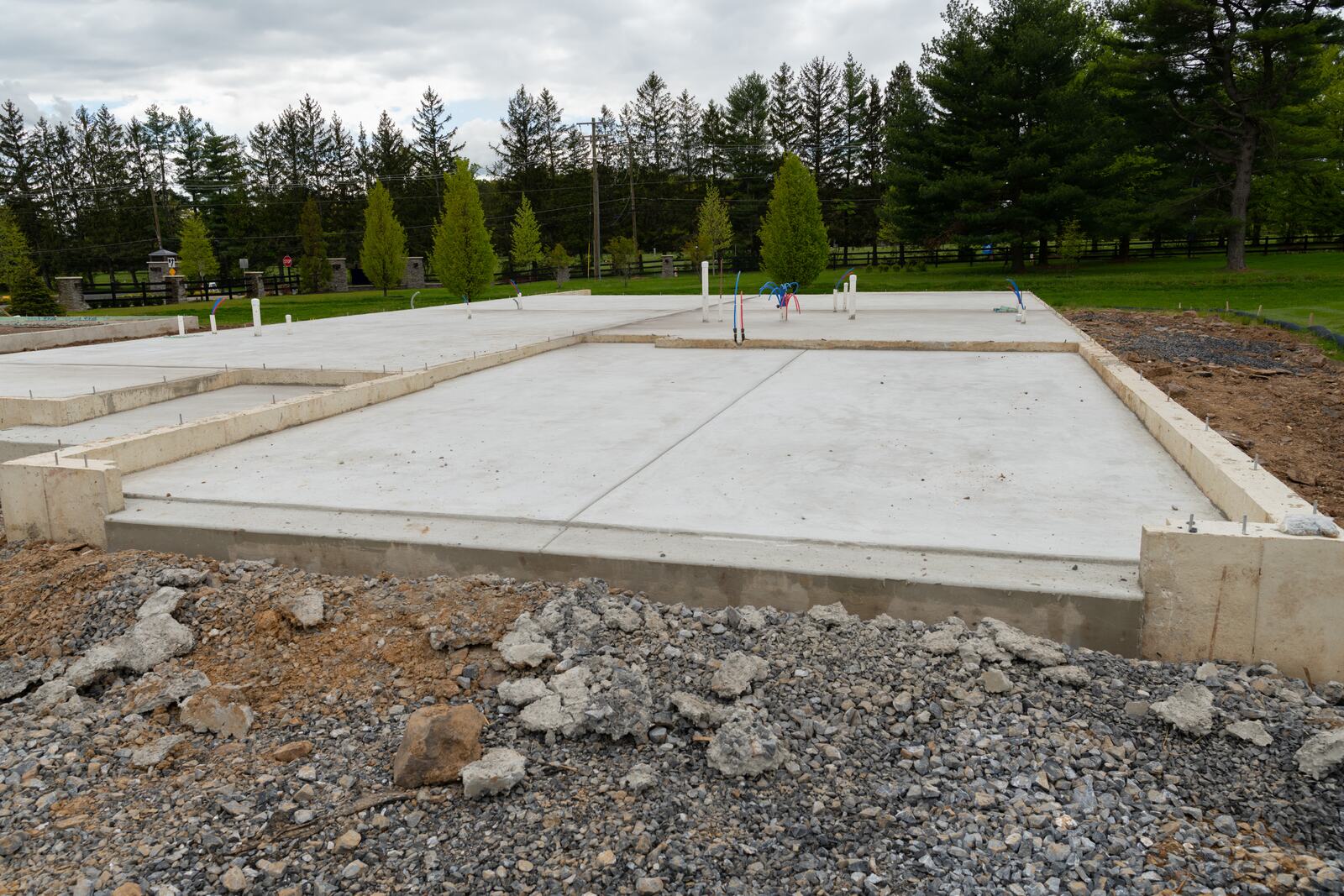 Concrete slab on grade with footings and utility stub-outs for building construction